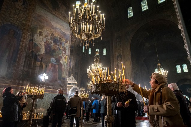 Uma mulher acende velas durante uma missa de Natal na catedral Alexander Nevsky em Sófia, na Bulgária