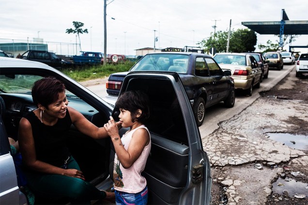 Jardeliani Brito, 33, com a filha na fila, aguarda para atravessar a fronteira para abastecero carro na Venezuela.