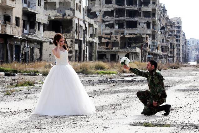 A noiva Nada Merhi, de 18 anos, e o soldado sírio Hassan Youssef, de 27 anos, posam para fotos de casamento entre prédios destruídos pela guerra na cidade de Homs - 05/02/2016