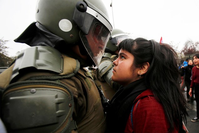 Manifestante encara policial durante protesto que marca os 43 anos do golpe militar chileno, na capital Santiago - 11/09/2016