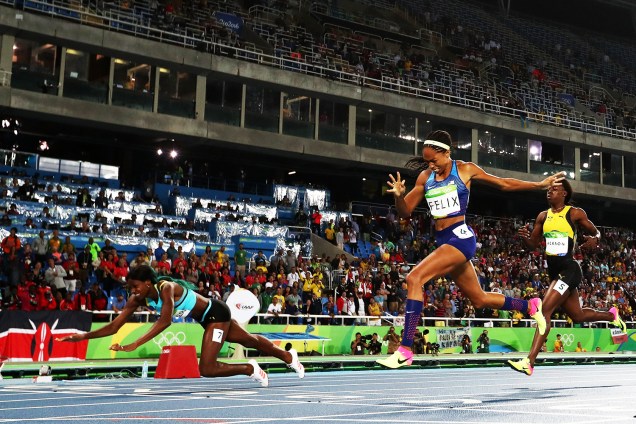 A atleta de Bahamas, Shaunae Miller (esq), 'mergulha' próxima da linha de chegada para conquistar a medalha de ouro na prova dos 400m feminino, a frente da americana Aliyson Feliz (centro), nos Jogos Olímpicos Rio-2016 - 15/08/2016