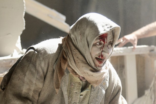 Mulher é vista ferida após ataque aéreo em um bairro controlado por rebeldes em Alepo, na Síria