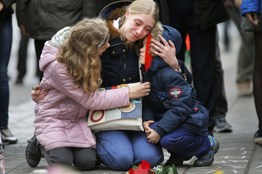 Mulher chora e abraça seus filhos em um memorial às vítimas dos ataques em Bruxelas, na Bélgica