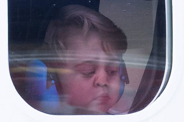 Príncipe George olha da janela do avião antes de partir da cidade de Victoria, durante visita da família real britânica ao Canadá