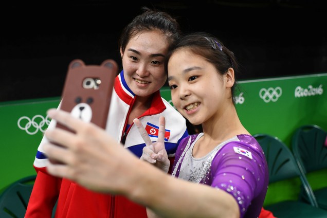 As ginastas Lee Eun-Ju da Coréia do Sul (à dir.) tira uma selfie com Hong Un Jong da Coréia do Norte durante as competições da Rio-2016