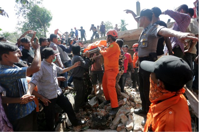 Bombeiros e civis socorrem as vítimas do terremoto na Indonésia