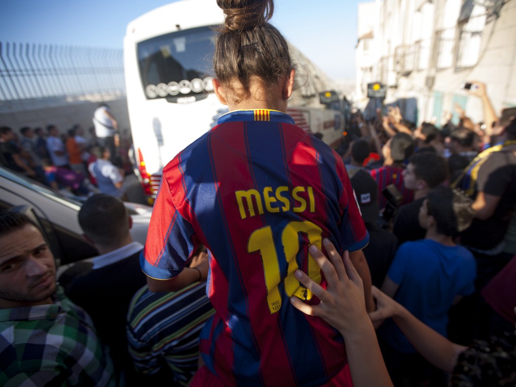 Torcedores palestinos festejam a chegada do time do Barcelona em Belém, na Cisjordânia. O time espanhol viajou para Israel e a Cisjordânia em 2013 para um "tour da paz". (Crédito: Dan Dennison/Getty Images)