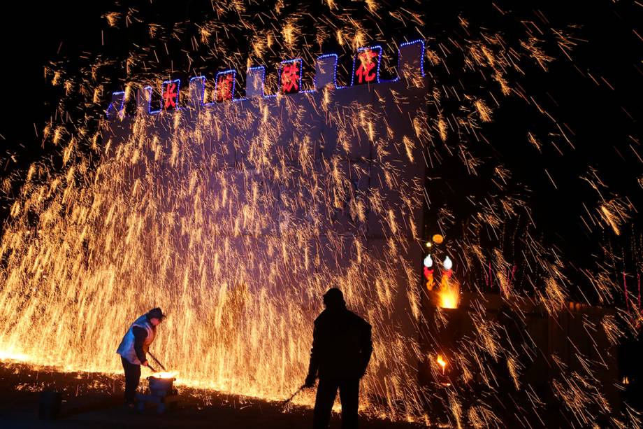 Homens atiram ferro derretido em uma parede durante as festividades do ano novo chinês, na China