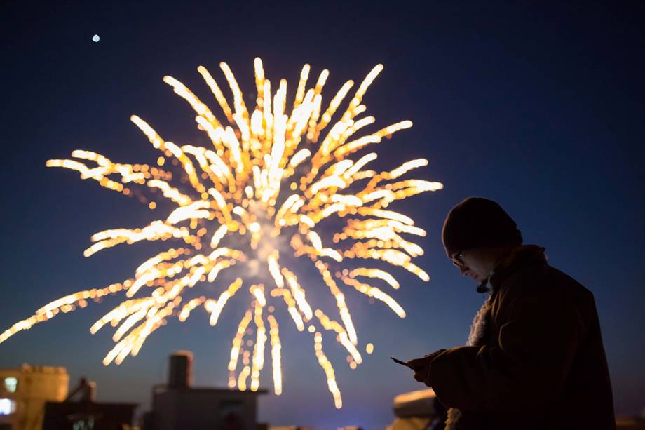 Pessoas assistem à exibição de fogos de artifício durante as festividades do ano novo chinês, na China