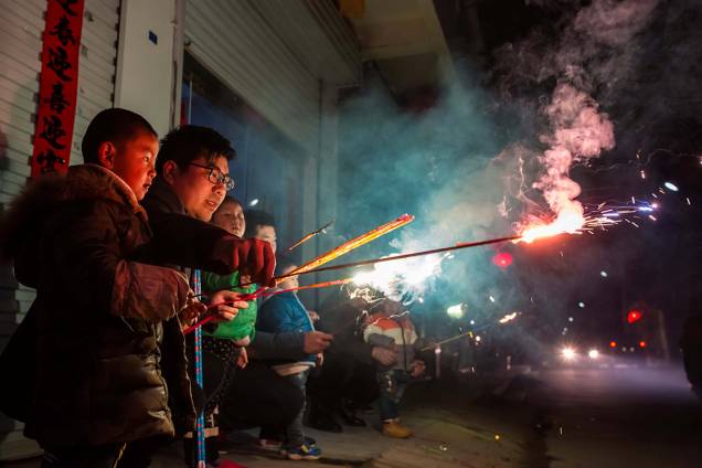 Crianças brincam com sinalizadores durante as festividades do ano novo chinês, na China Crianças brincam com sinalizadores durante as festividades do ano novo chinês, na China