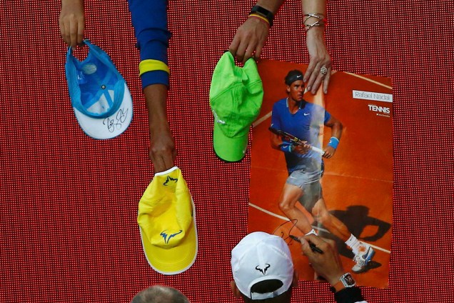 O espanhol Rafael Nadal dá autógrafos após vencer a partida contra o alemão Alexander Zverev, em Melbourne