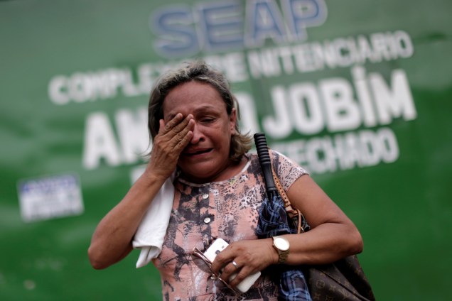 Parente de um presidiário chora em frente à entrada principal  do Complexo Penitenciário Anisio Jobim em Manaus