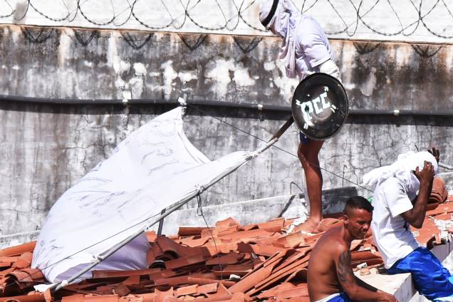 Preso utiliza escudo com as iniciais do PCC durante rebelião na Penitenciária Estadual de Alcaçuz, em Natal, no Rio Grande do Norte - 16/01/2017 Preso utiliza escudo com as iniciais do PCC durante rebelião na Penitenciária Estadual de Alcaçuz, em Natal, no Rio Grande do Norte - 16/01/2017