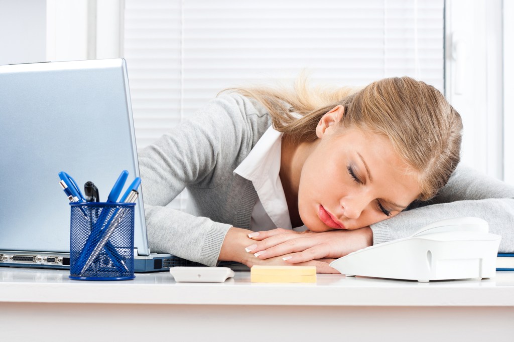 Beautiful tired business woman sleeping at work.