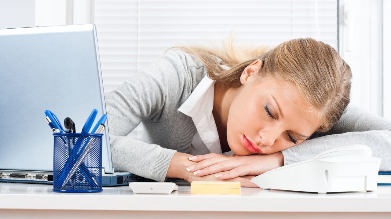 Beautiful tired business woman sleeping at work.