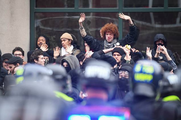 Manifestantes são cercados por policiais durante protesto contra o presidente eleito dos Estads Unidos, Donald Trump