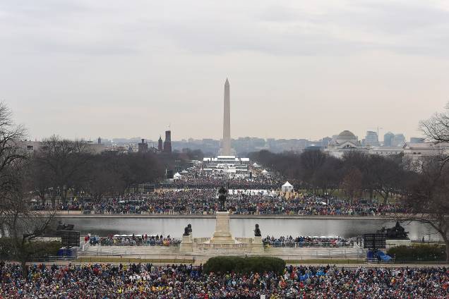 Pessoas começam a chegar para a cerimônia de posse de Donald Trump diante do Monumento de Washington enquanto parte da cidade é iluminada pelo sol no amanhecer