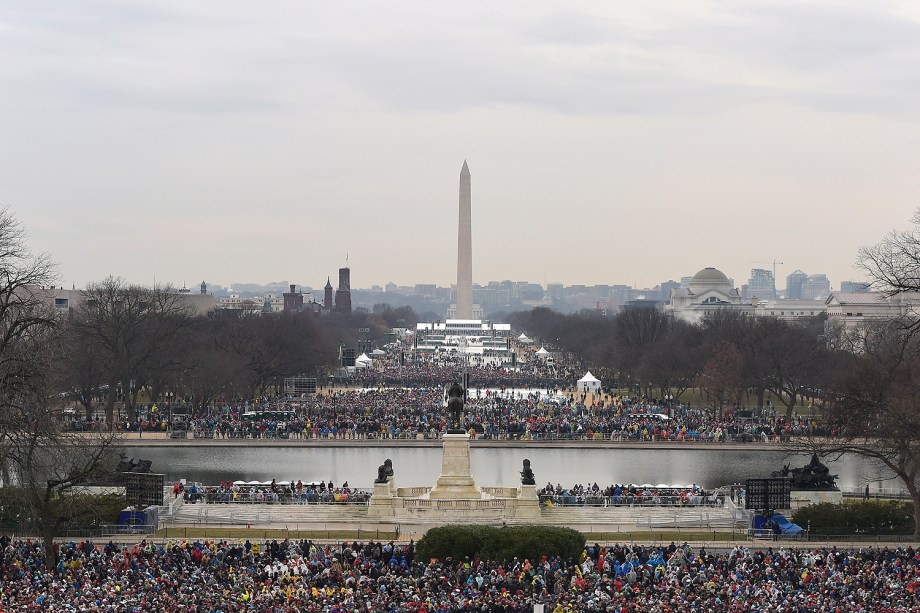 Pessoas começam a chegar para a cerimônia de posse de Donald Trump diante do Monumento de Washington enquanto parte da cidade é iluminada pelo sol no amanhecer