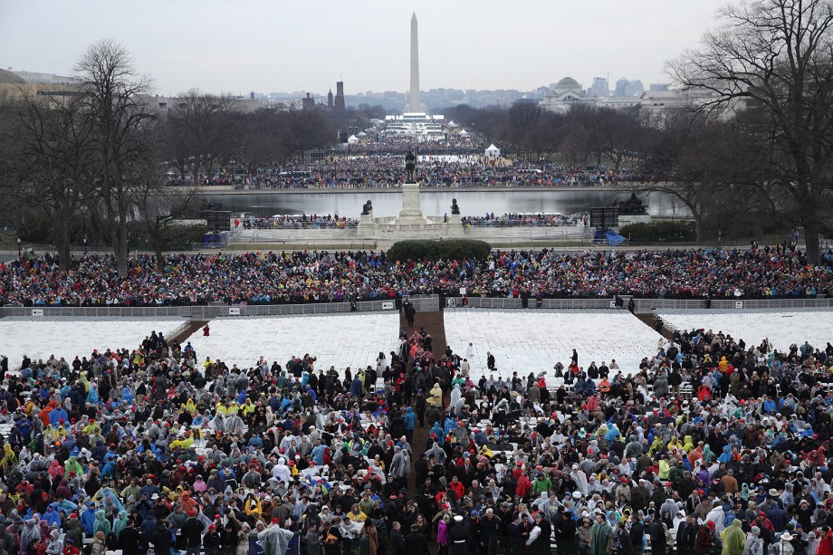 Pessoas começam a chegar para a cerimônia de posse de Donald Trump diante do Monumento de Washington enquanto parte da cidade é iluminada pelo sol no amanhecer