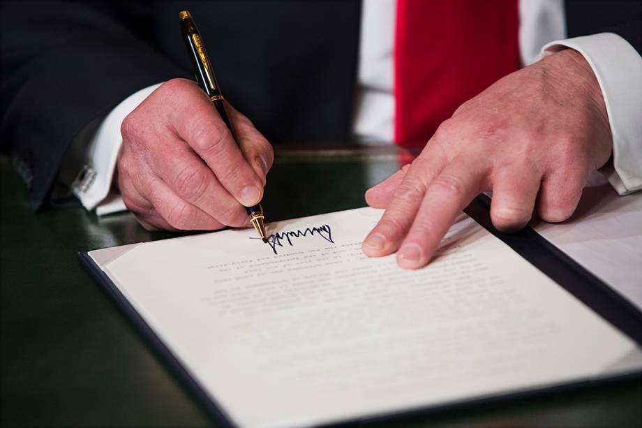 Donald Trump assina documento durante sua posse como presidente dos Estados Unidos