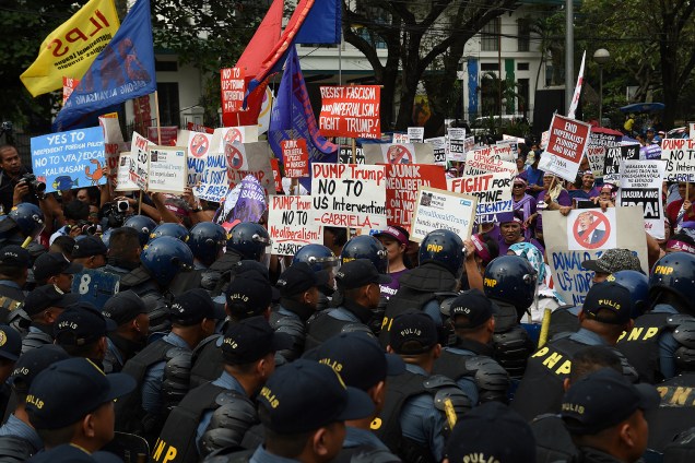 Manifestantes são contidos por uma barreira de policiais em frente à embaixada dos EUA em Manila, nas Filipinas, em protesto no dia da posse de Donald Trump como presidente - 20/01/2017