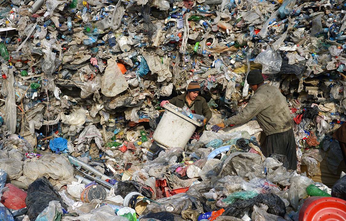 Jovens afegãos coletam metal e plástico em um aterro para venderem para reciclagem, nos arredores de Mazar-i- Sharif, Afeganistão