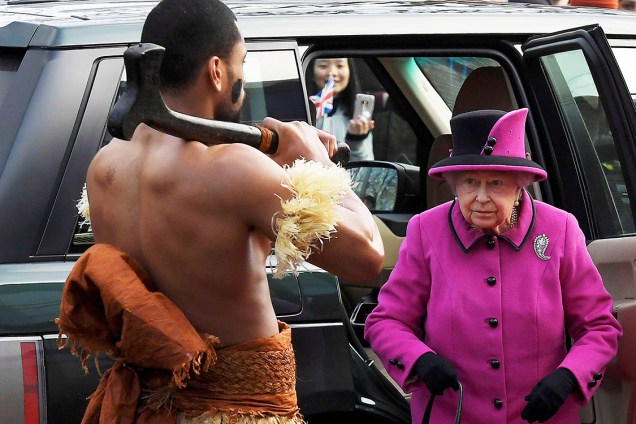 A rainha Elizabeth observa um homem com vestimentas tradicionais durante uma exposição sobre Fiji no Centro de Artes Visuais Sainsbury, na Inglaterra