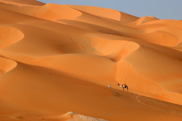 Homem anda com seu camelo através do deserto de Liwa, a oeste de Abu Dhabi, durante o Moreeb Dune Festival - 02/01/2017