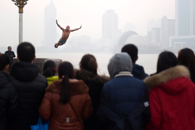 Homem mergulha para comemorar o ano novo em Qingdao, província de Shandong, na China