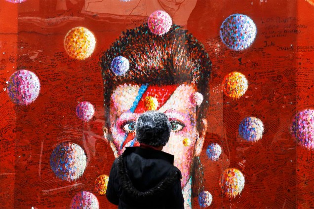 Mulher observa mural em Brixton, no sul de Londres, com retrato do cantor David Bowie, morto em janeiro de 2016 - 10/01/2017