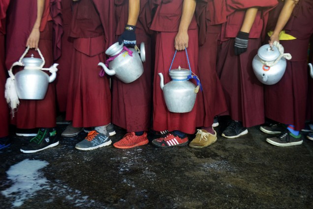 Monges budistas fazem fila para coletar leite quente e distribuir aos devotos durante evento com a presença do líder tibetano O Dalai Lama em Bodhgaya, na Índia - 04/01/2017