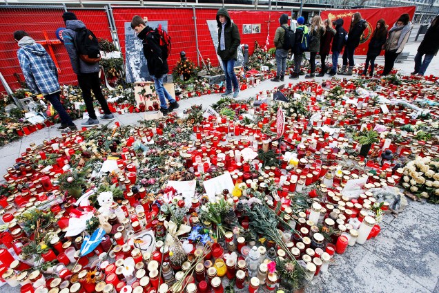 Pessoas deixam flores e velas próximas ao local onde caminhão atropelou dezenas de pessoas, em um feira de Natal de Berlim, na Alemanha - 19/01/2017