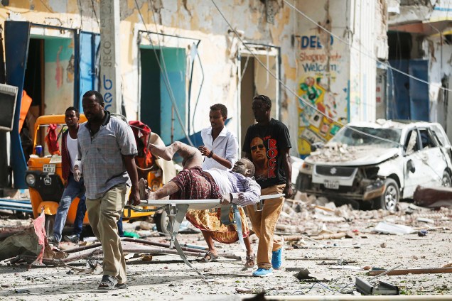 Homem é carregado após explosão em frente o hotel Dayah, em Mogadíscio, Somália - 25/01/2017