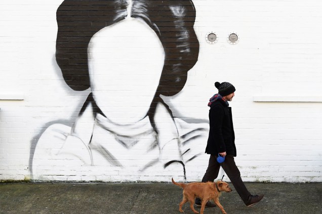 Homem e seu cão caminham próximos de um mural dedicado à Princesa Leia, da franquia 'Star Wars', em Belfast, capital da Irlanda do Norte - 11/01/2017