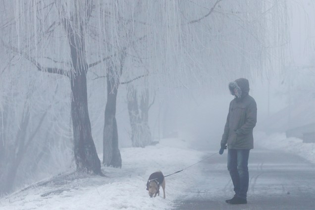 Homem caminha com seu cão em um dia nublado na cidade de Kiev, capital da Ucrânia - 17/01/2017