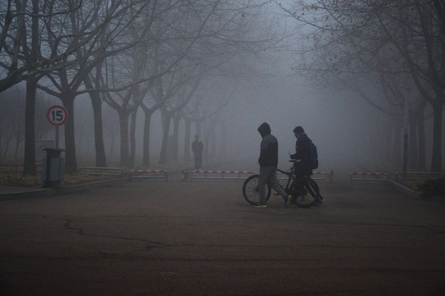 Pessoas caminham através de uma densa camada de poluição em uma rua da cidade de Qingdao, na província de Shandong, na China - 04/01/2016