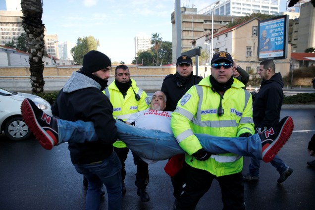 Policiais carregam um defensor do soldado israelense Elor Azaria, acusado pelo homicídio de um palestino ferido, durante um protesto diante do tribunal militar de Tel Aviv - 04/01/2017
