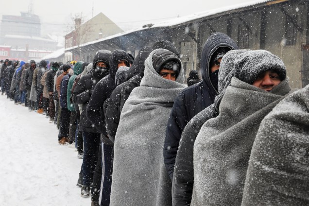 Migrantes aguardam em fila para receber alimentos, durante nevasca em Belgrado, na Sérvia - 11/01/2017