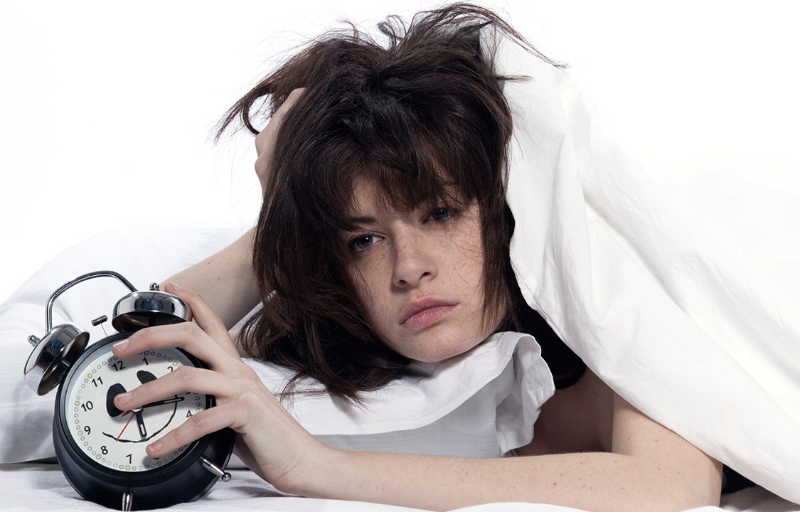 young woman in a white sheet bed on white background