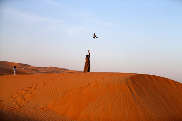 Homem treinar falcão no meio do deserto de Liwa, a 250 quilômetros do Golfo Pérsico, durante o Festival das Dunas Liwa Moreeb, nos Emirados Árabes