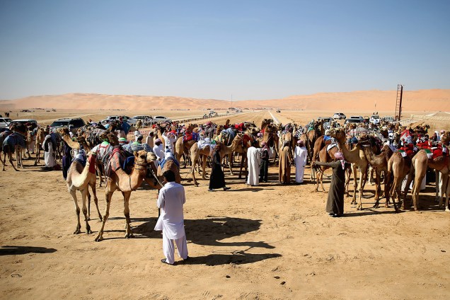 Participantes se reúnem no deserto de Liwa, próximo ao Golfo Pérsico, para assistir corrida de camelos, principal atração do Festival das Dunas Liwa Moreeb, nos Emirados Árabes