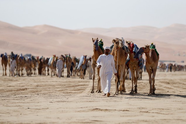Participantes se reúnem no deserto de Liwa, próximo ao Golfo Pérsico, para assistir corrida de camelos, principal atração do Festival das Dunas Liwa Moreeb, nos Emirados Árabes