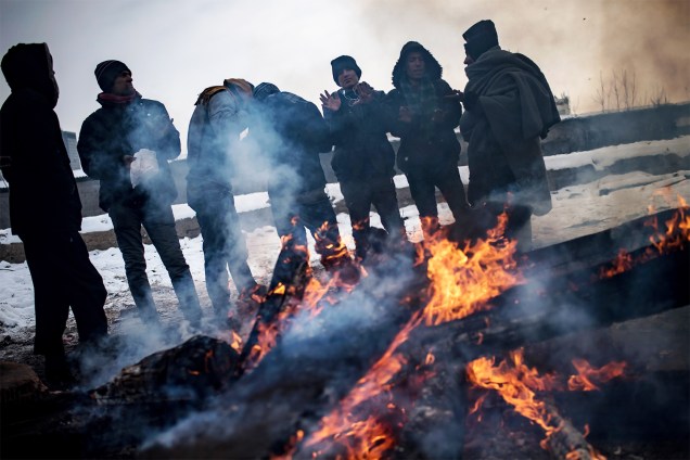 Migrantes se aquecem em volta de uma fogueira, próximo de armazém abandonado em Belgrado, na Sérvia - 10/01/2017