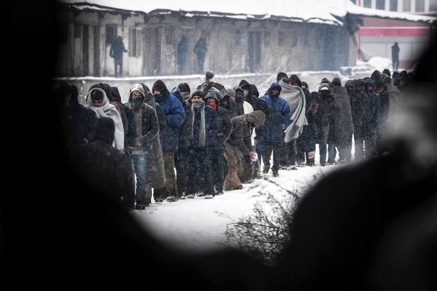 Migrantes fazem fila para receber alimentos distribuídos por voluntários em Belgrado, na Sérvia - 11/01/2017