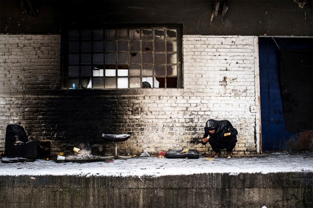 Migrante se alimenta em um armazém abandonado de Belgrado, na Sérvia - 11/01/2017