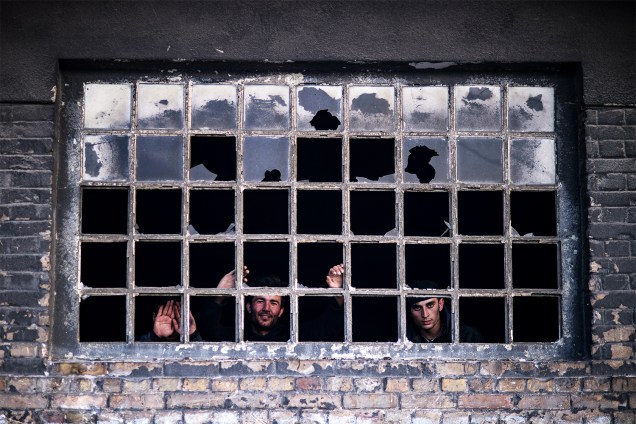 Migrantes são fotografados em uma janela de armazém abandonado de Belgrado, na Sérvia - 15/01/2017