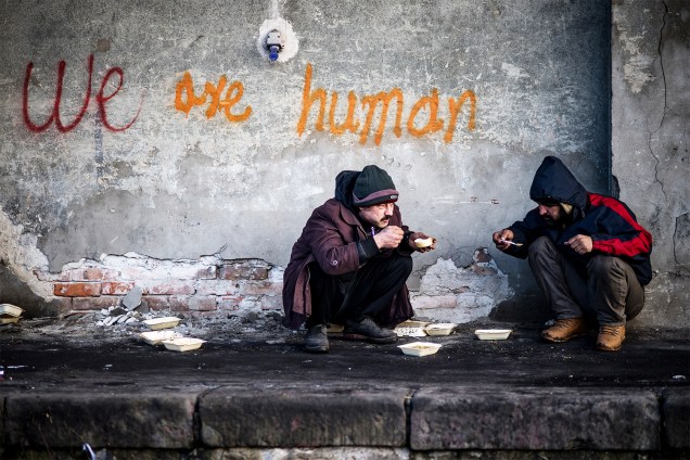 Migrantes se alimentam em um armazém abandonado de Belgrado, na Sérvia - 15/01/2017