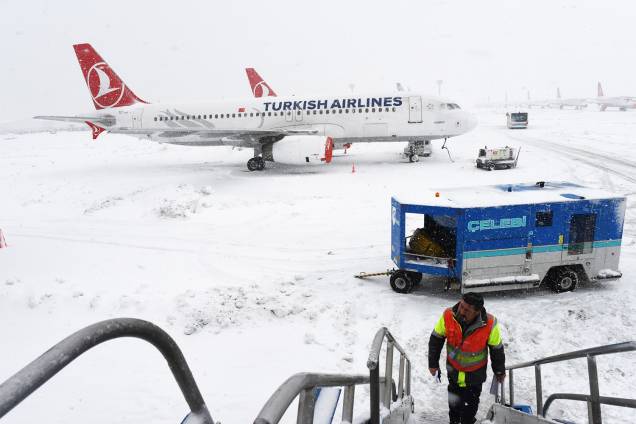 Funcionário do aeroporto Ataturk, em Istambul, na Turquia, sobe as escadas de um avião, após forte nevasca atingir a região - 09/01/2017