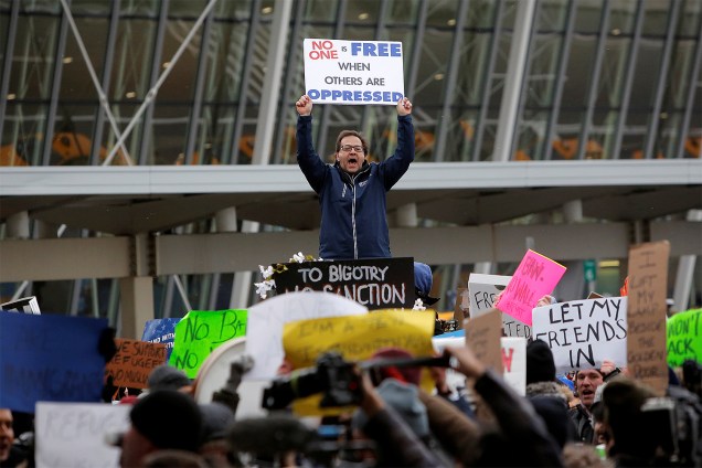 Manifestantes protestam no lado de fora do Terminal 4 do Aeroporto Internacional John F. Kennedy, contra o decreto do presidente Donald Trump para barrar a entrada de cidadãos de sete países muçulmanos nos Estados Unidos  - 28/01/2017