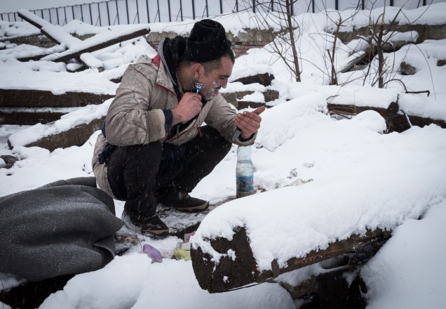 Imigrante faz a barba cercado de neve em Belgrado, Sérvia